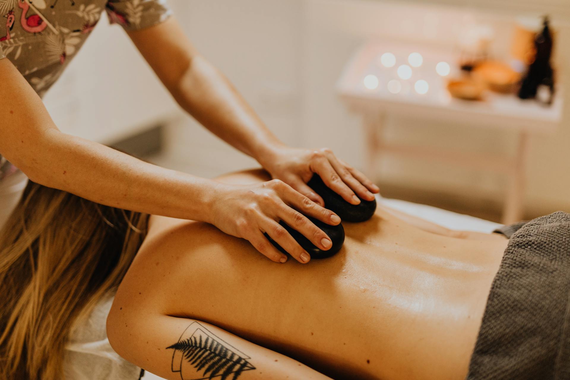 The therapist puts hot stones on the customer's back during the hot stone massage session.